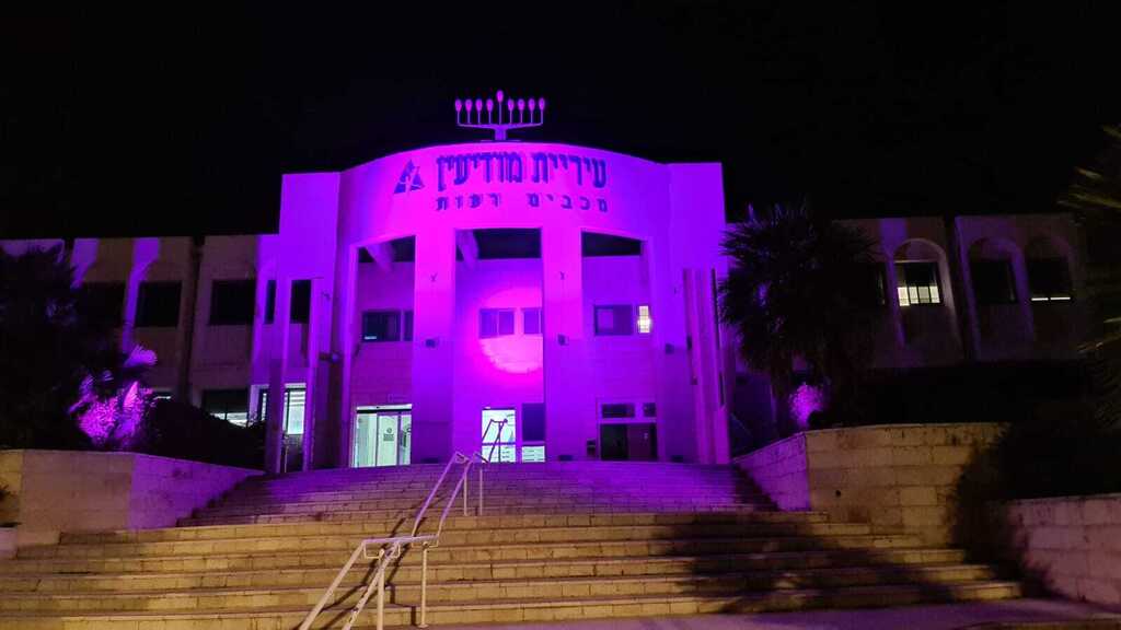 Здание мэрии Модиина, подсвеченное пурпурным светом 