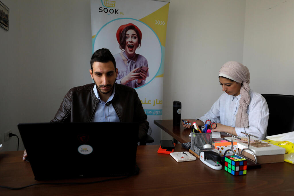 Palestinians Lutfi Alatrash (L) and Samah Ayyad, co-founders of Palestinian online marketplace company sook.ps, work in their office in the West Bank, October 19, 2021