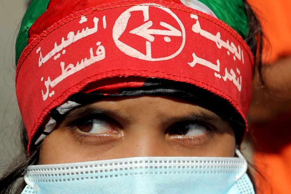 A girl wearing a protective face mask and the headband of the Popular Front for the Liberation of Palestine (PFLP) looks on during a rally to show solidarity with hunger-striking Palestinian prisoner Maher Al-Akhras, who is held by Israel, in Gaza  