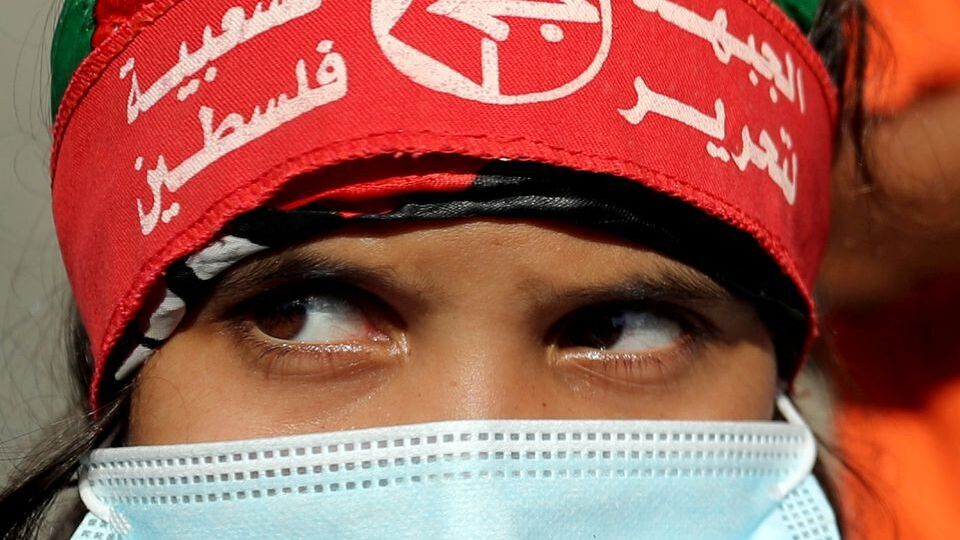 A girl wearing a protective face mask and the headband of the Popular Front for the Liberation of Palestine (PFLP) looks on during a rally to show solidarity with hunger-striking Palestinian prisoner Maher Al-Akhras, who is held by Israel, in Gaza  