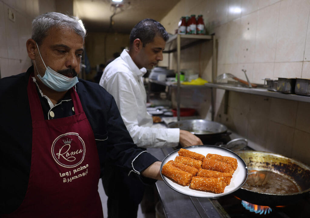 Moin Abu Hassira shows a plate of fried fish