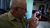 Munir Hamo talks to his daughter and granddaughter, who live in Jordan