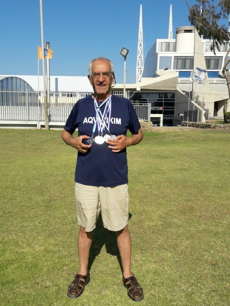 Baruch Meiri, 80, shows off his swimming medals