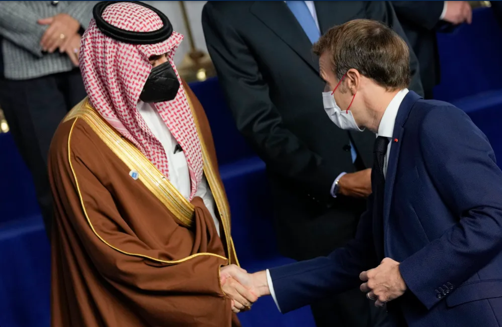 French President Emmanuel Macron, right, greets Saudi Foreign Minister Prince Faisal bin Farhan Al Saud at the La Nuvola conference center for the G20 summit in Rome, October 30, 2021