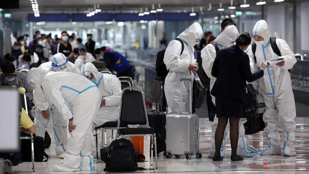 תיירים מ סין עם חליפות מגן קורונה נוחתים בנמל תעופה במחוז סמוט פראקן ב תאילנד ליד פוקט במסגרת הקלות על כניסת זרים למדינה  