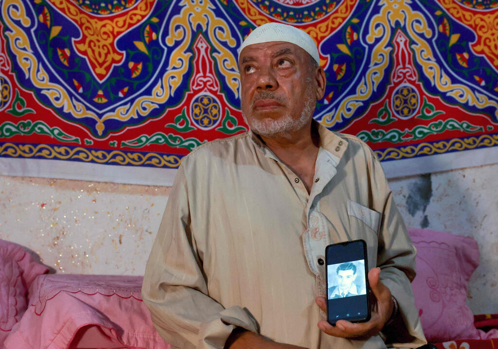Bassam Barbakh, displays a photo of one of his late brothers killed by Israeli soldiers (Photo: AFP) Bassam Barbakh, displays a photo of one of his late brothers killed by Israeli soldiers