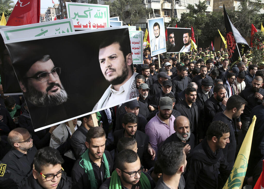 Supporters of Iranian-backed Hezbollah hold portraits of Hassan Nasrallah and Abdul-Malik al-Houthi, the leader Beirut in  2016