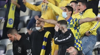 אוהדים ביציע עם מסיכות