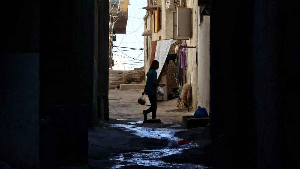 A Palestinian girl carries food on her way back home at al-Shati refugee camp in Gaza 