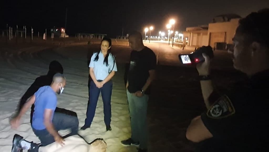 Подозреваемый дает показания (Фото: пресс-служба полиции) החשוד משחזר את התקיפה בזירה עם חוקרי המשטרה