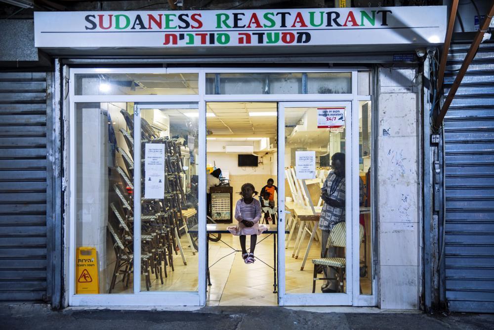 A Sudanese migrant family are seen in a closed Sudanese restaurant in south Tel Aviv 