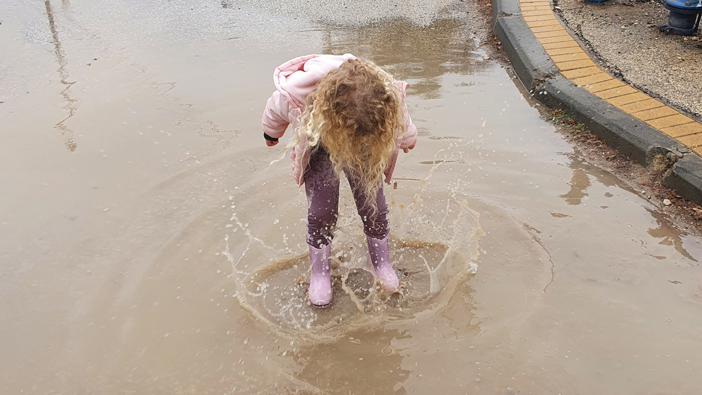 הילדה גולן קופצת בין השלוליות של תל עדשים