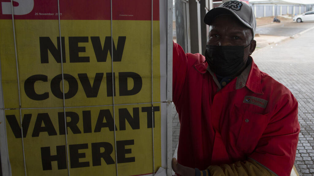 A petrol attendant stands next to a newspaper headline in Pretoria, South Africa