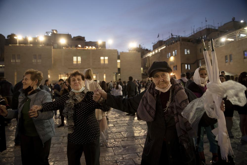 Holocaust survivors dance during a Hanukkah menorah lighting ceremony at the Western Wall, in the Old City of Jerusalem 