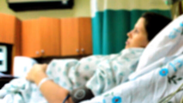 A pregnant woman lying in a hospital bed 