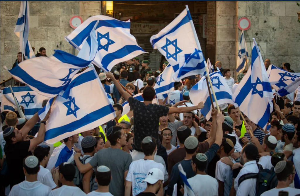 Israelis hold Israeli flags and dance during the March of Flags at Damascus Gate in Jerusalem's Old City, June 15, 2021