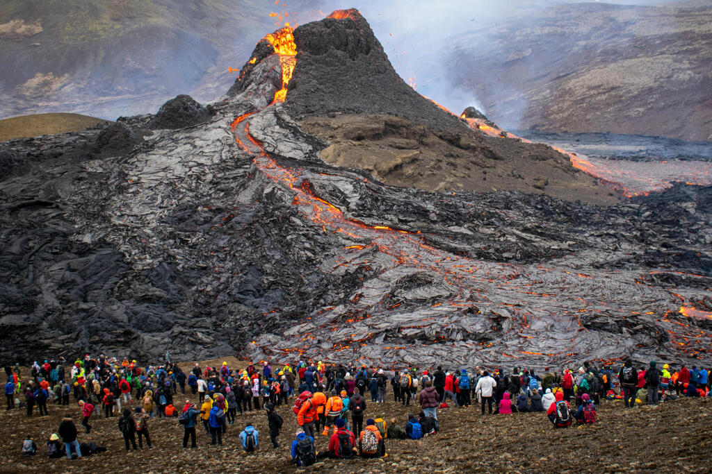 תמונות השנה של AFP שנת 2021 מטיילים מגיעים להר הגעש פגרדלספג'ל ב איסלנד רייקיאוויק 21 מרץ