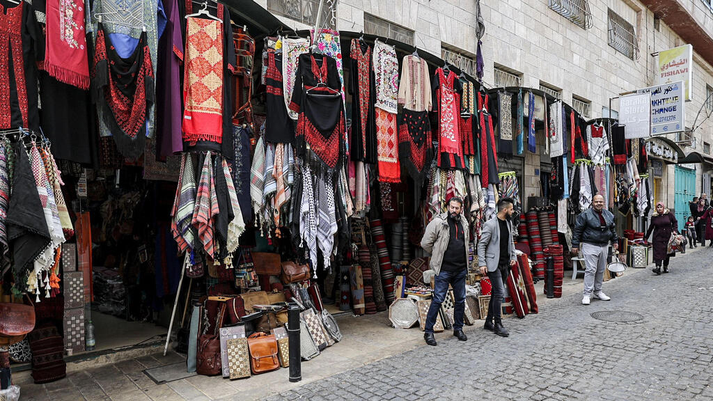 Shopkeepers stand outside their tourist-free venues in the biblical West Bank city of Bethlehem on December 15, 2021 
