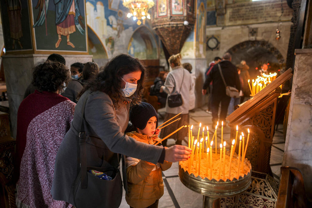 People light candles in the Greek Orthodox Church of the Annunciation in Nazareth 