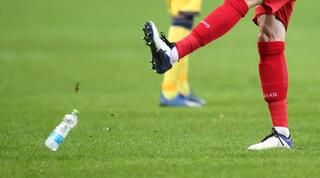 בקבוק שהושלך לכר הדשא מהיציע