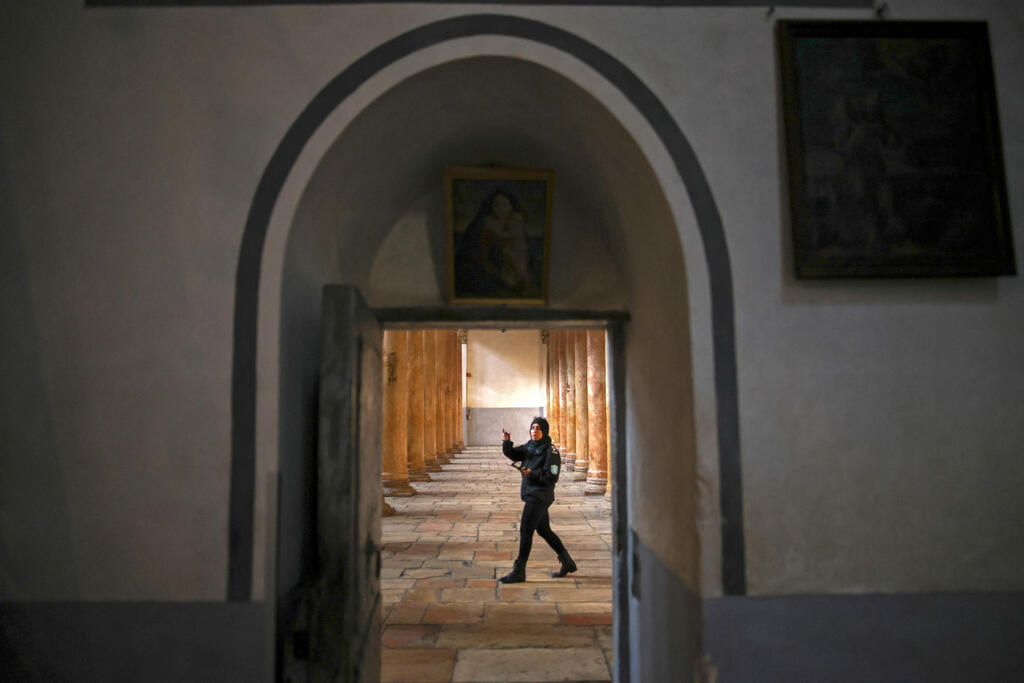 A local security guard walks in the Church of the Nativity in Bethlehem days before Christmas  