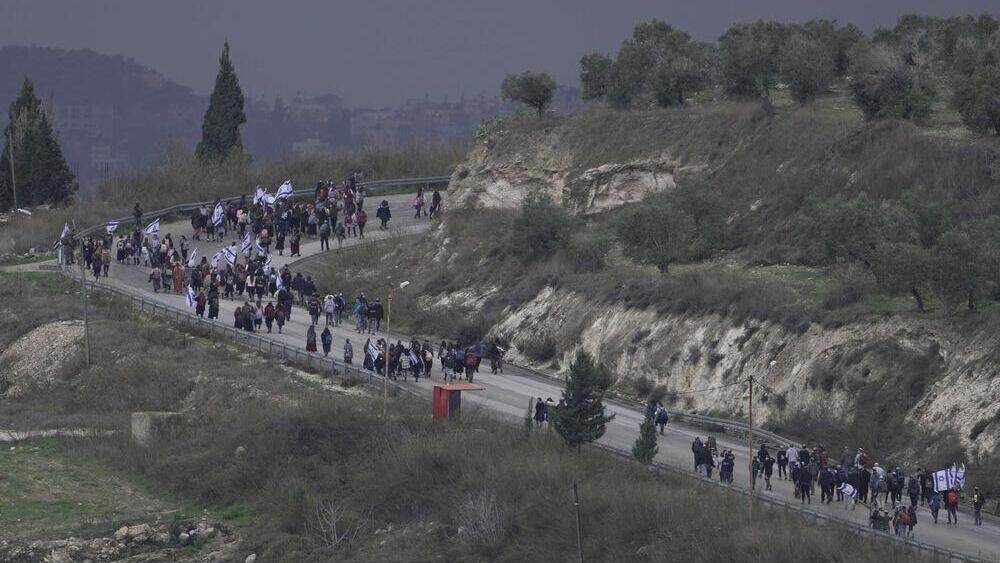 ewish settlers march,  during a protest against plans to dismantle the outpost's seminary, along a road between the West Bank outpost of Homesh