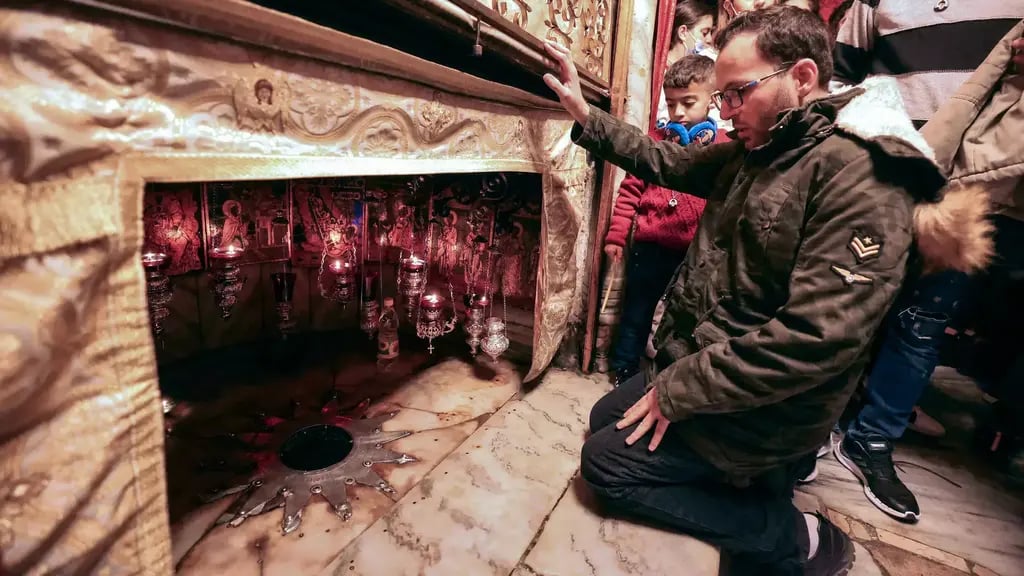 Ayyad kneels before the 14-pointed star marking the birthplace of Jesus, according to tradition, inside the Grotto at the Church of the Nativity 
