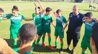 השחקנים הירוקים יחד עם המאמן  (מערכת ONE)