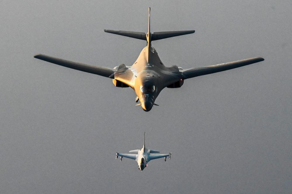 a Royal Bahraini Air Force F-16C Fighting Falcon, lower, flies in formation with a U.S. Air Force B-1B Lancer over the Persian Gulf 