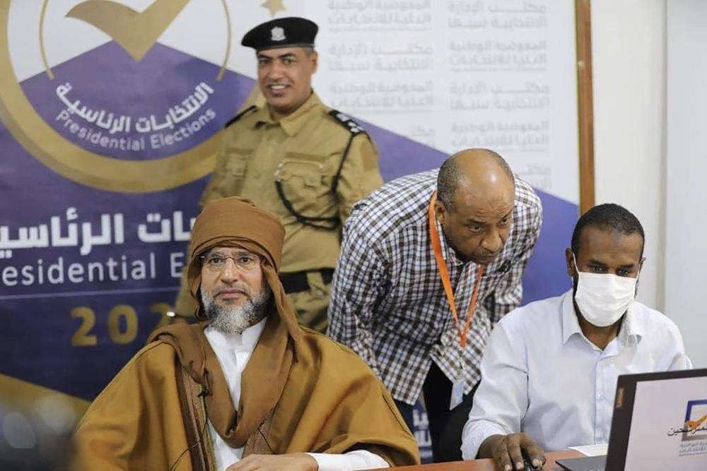 Seif al-Islam Gadhafi, left, the son and one-time heir apparent of late Libyan dictator Moammar Gadhafi registers his candidacy for the country's presidential elections next month in Sabha, Libya 