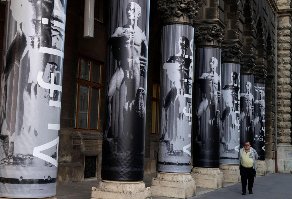 A man walks past the Vienna Museum with posters on the buildings' columns featuring the current art exhibition titled "Vienna Falls in Line. The Politics of Art under National Socialism" showing Nazi artifacts at the city's "Vienna Museum" 