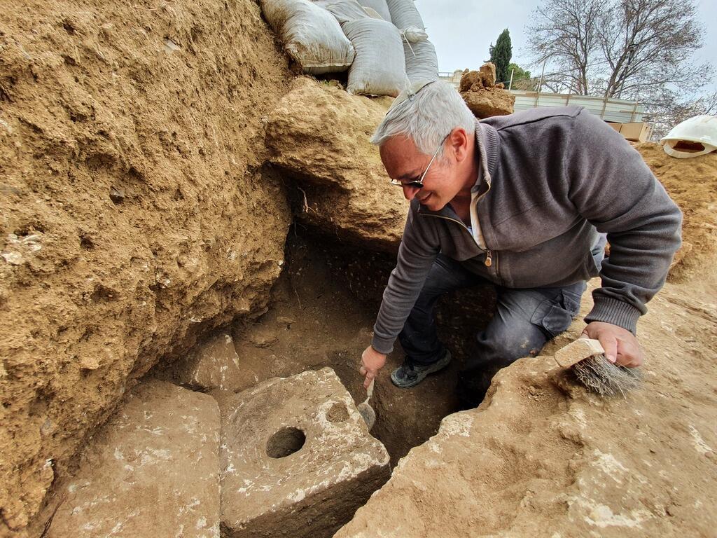 Archiologist Ya’akov Billig near the ancient toilet uncovered in a Jerusalem dig 