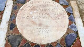 במרכז המבנה נחשף לוח אבן עם כתובת ביוונית ובסופו המילה "שלום" בעברית וסמל המנורה