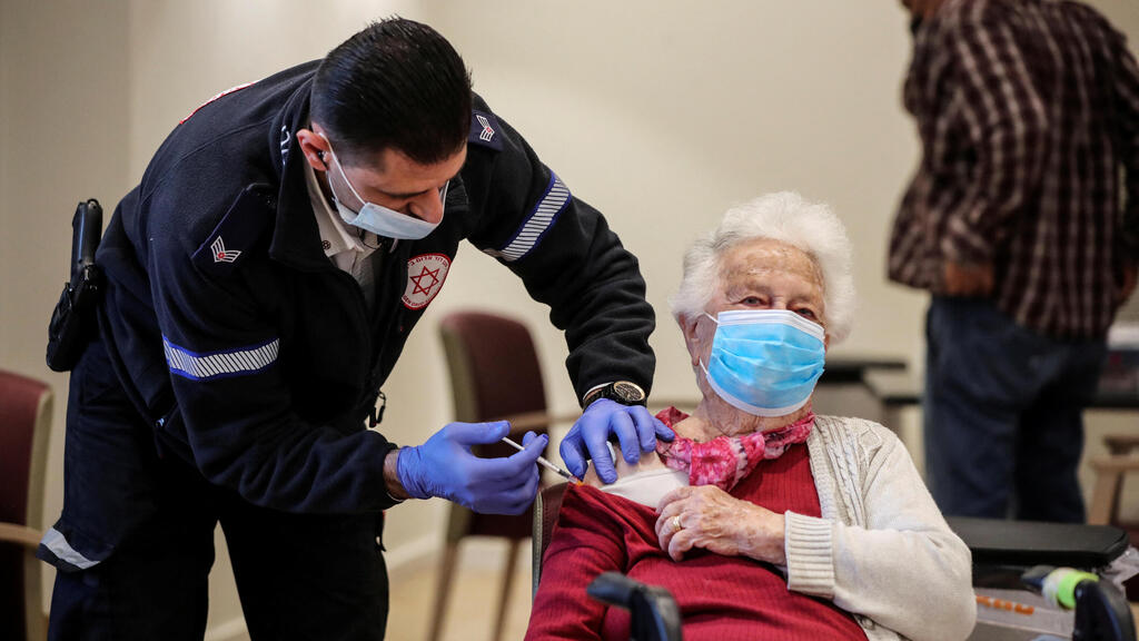 93-year-old Shari Marco receives a fourth dose of the coronavirus disease (COVID-19) vaccine following a vaccination party after Israel approved a second booster shot for the immunocompromised, people over 60 years and medical staff in a retirement home in Netanya 