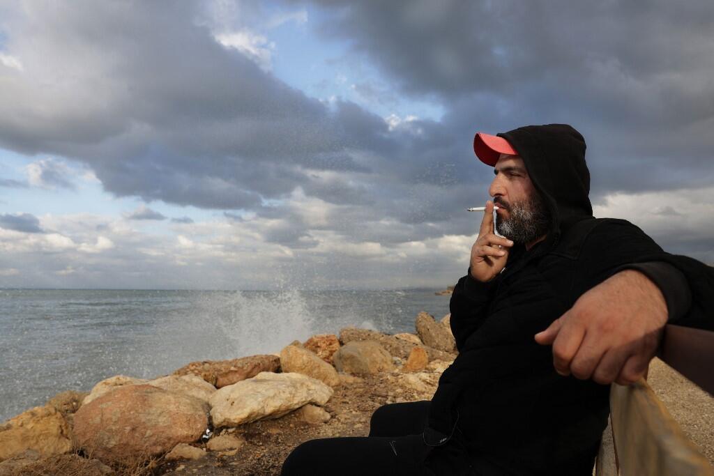 Lebanese would-be-migrant Bilal Moussa, 34, smokes a cigarette by the sea in Tripoli north of Beirut 