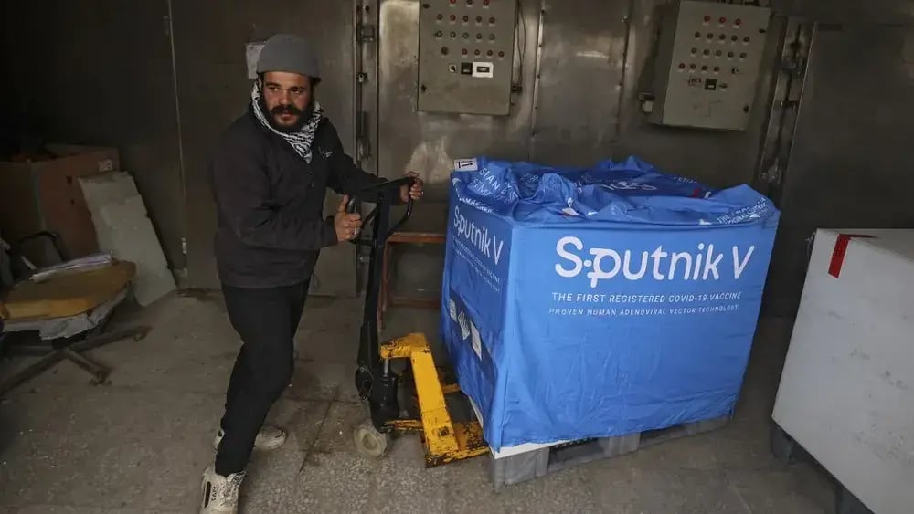  Palestinian laborer unloads a box of the Sputnik V vaccine, donated by the United Arab Emirates,