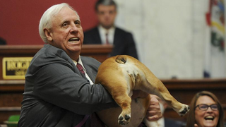 מושל מערב וירג'יניה ג'ים ג'סטיס מראה את אחורי ה כלבה תוקף את בט מידלר