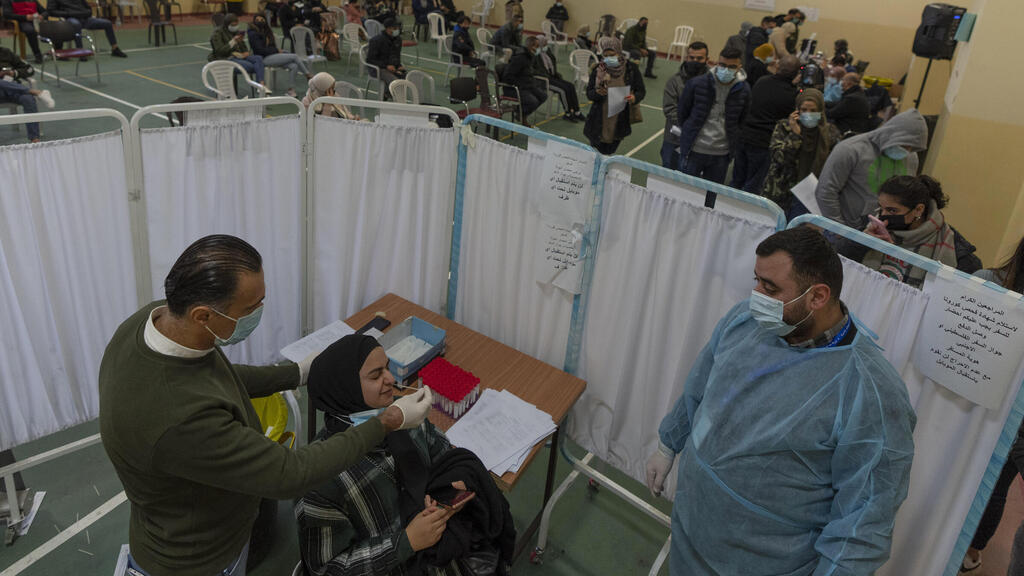 A health care worker takes a nasal swab sample from a Palestinian woman in a COVID-19 testing center, in the West Bank city of Ramallah (Photo: AP) A health care worker takes a nasal swab sample from a Palestinian woman in a COVID-19 testing center, in the West Bank city of Ramallah