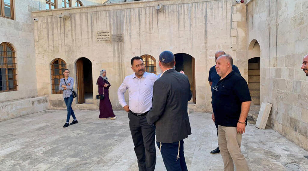 Rabbi Mendy Chitrik, wearing kippah, speaks with locals at the newly-renovated synagogue in Kilis, Turkey (Photo: Mendy Chitrik) Rabbi Mendy Chitrik, wearing kippah, speaks with locals at the newly-renovated synagogue in Kilis, Turkey
