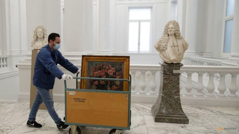 A museum staff carries the painting "Flowers" 