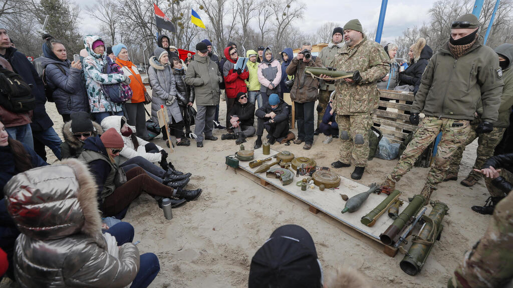 אוקראינה קייב אנשים מקבלים הסבר על שימוש בנשק באימון צבאי פתוח לאזרחים