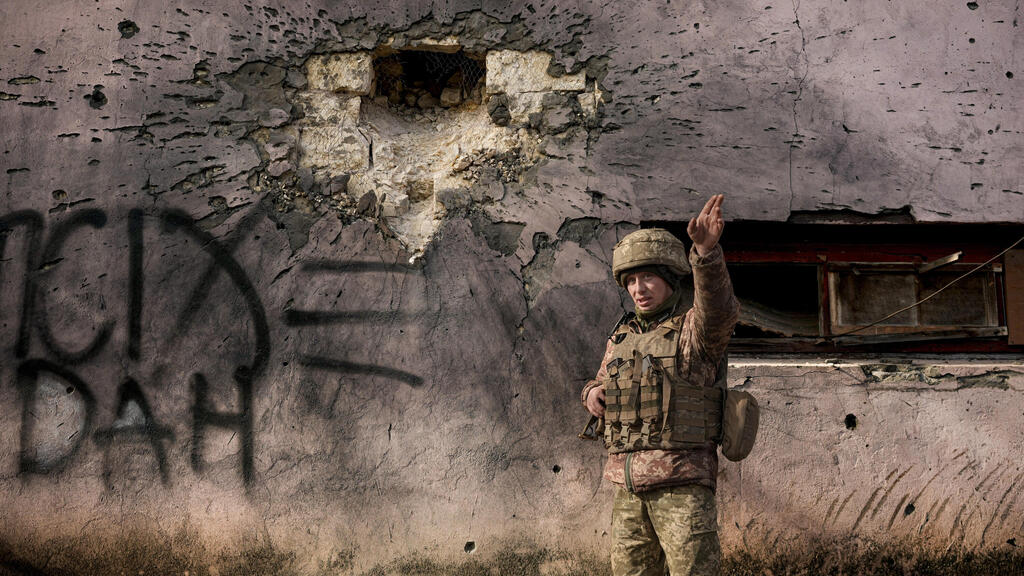  Ukrainian serviceman points to the direction of the incoming shelling in eastern Ukraine, 