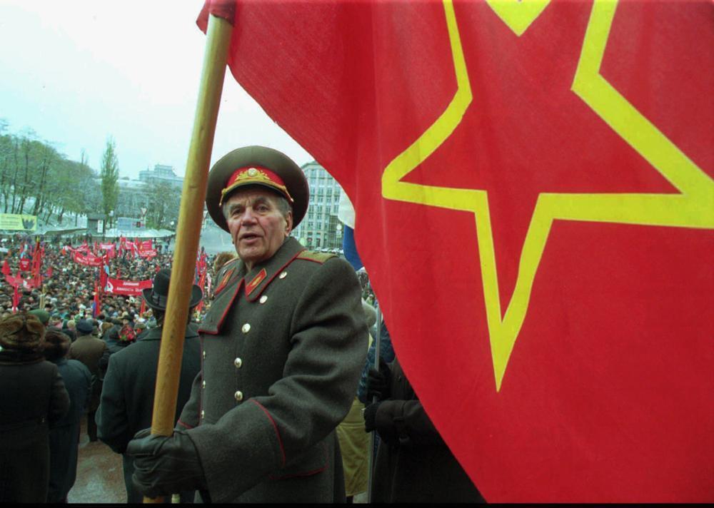 An unidentified general in a former Soviet army uniform, holds a red flag during a rally on the occasion of the 78th anniversary of the Bolshevik revolution, in Kiev 