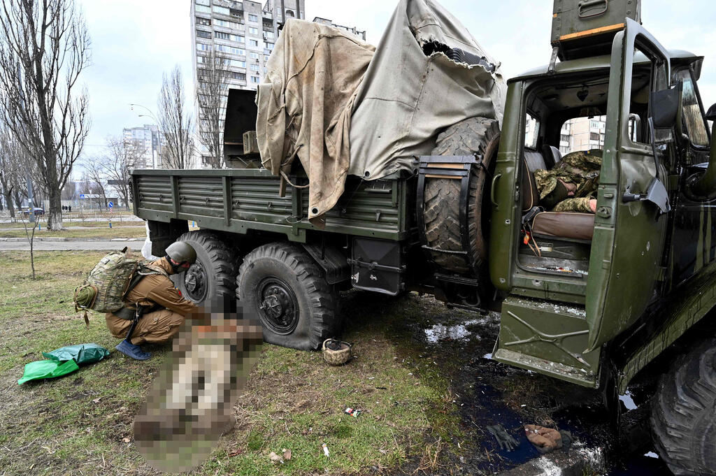 Ukrainian medic checks Russian casualties (Photo: AFP) פרמדיק אוקראיני ליד גופה של חייל רוסי