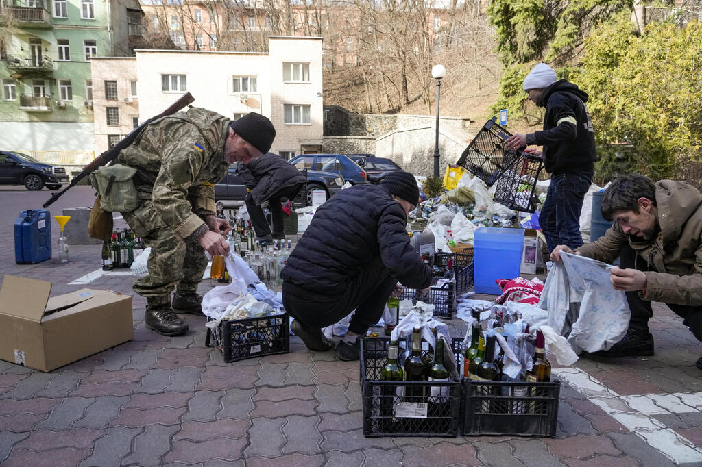 Ukrainian civilians gather Molotov cocktails for guerilla warfare against Russian forces (Photo: AP) אזרחים אוקראינים מכינים בקבוקי תבערה