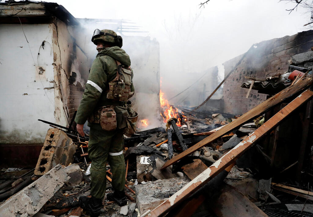 דונייצק אוקראינה חייל של מיליציה פרו רוסית עומד בהריסות של בית