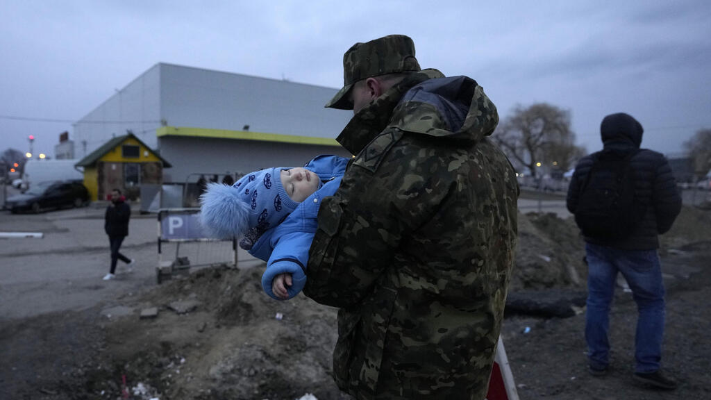 חייל פולני נושא תינוק אוקראיני בגבול פולין