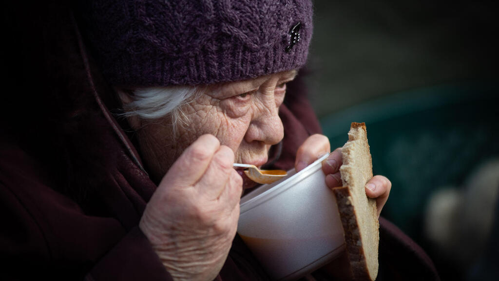 קשישה שותה מרק בגבול סלובקיה