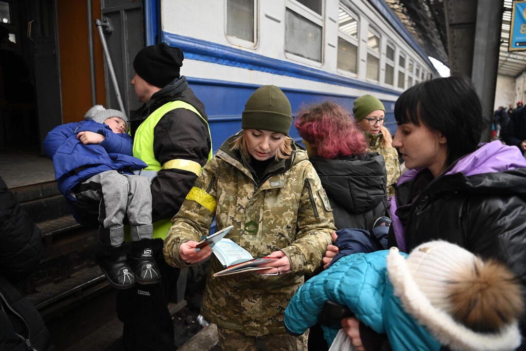 Ukrainian civilians flee to neighboring Poland (Photo: AFP) לבוב לביב ילדים עולים על ה רכב לפולין פליטים משבר מלחמה רוסיה אוקראינה בורחים נמלטיםן