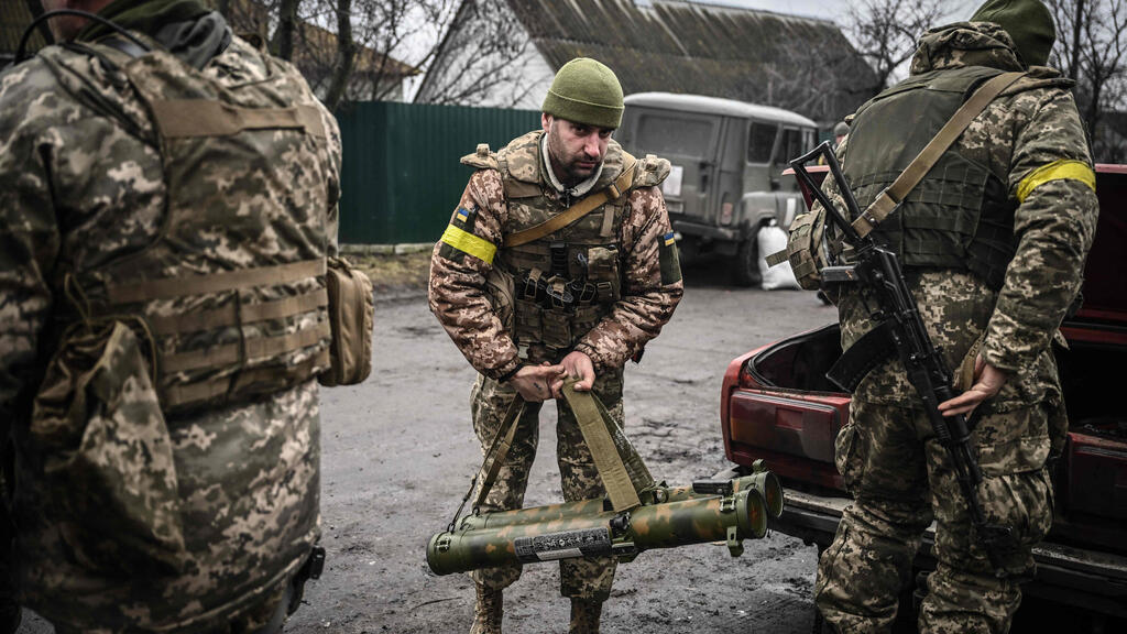 Ukrainian forces holding an anti-tank missile launcher north of Kyiv (Photo: AFP) חייל חיילים ב צבא אוקראינה מחזיקים ב משגר טיל טילים נגד טנקים נ"ט צפונית ל קייב מלחמה עם רוסיה